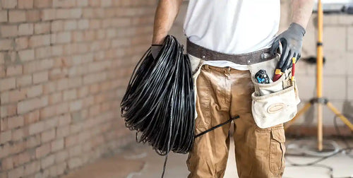 Trade worker carrying cables